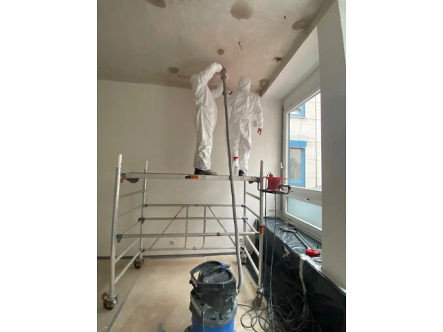Arbeiten mit Schutzanzug in einem Innenraum während der Sanierung