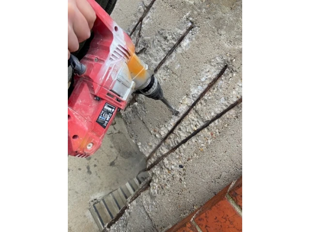 Bohrarbeiten in einer Mauerwerkswand während eines Rückbaus